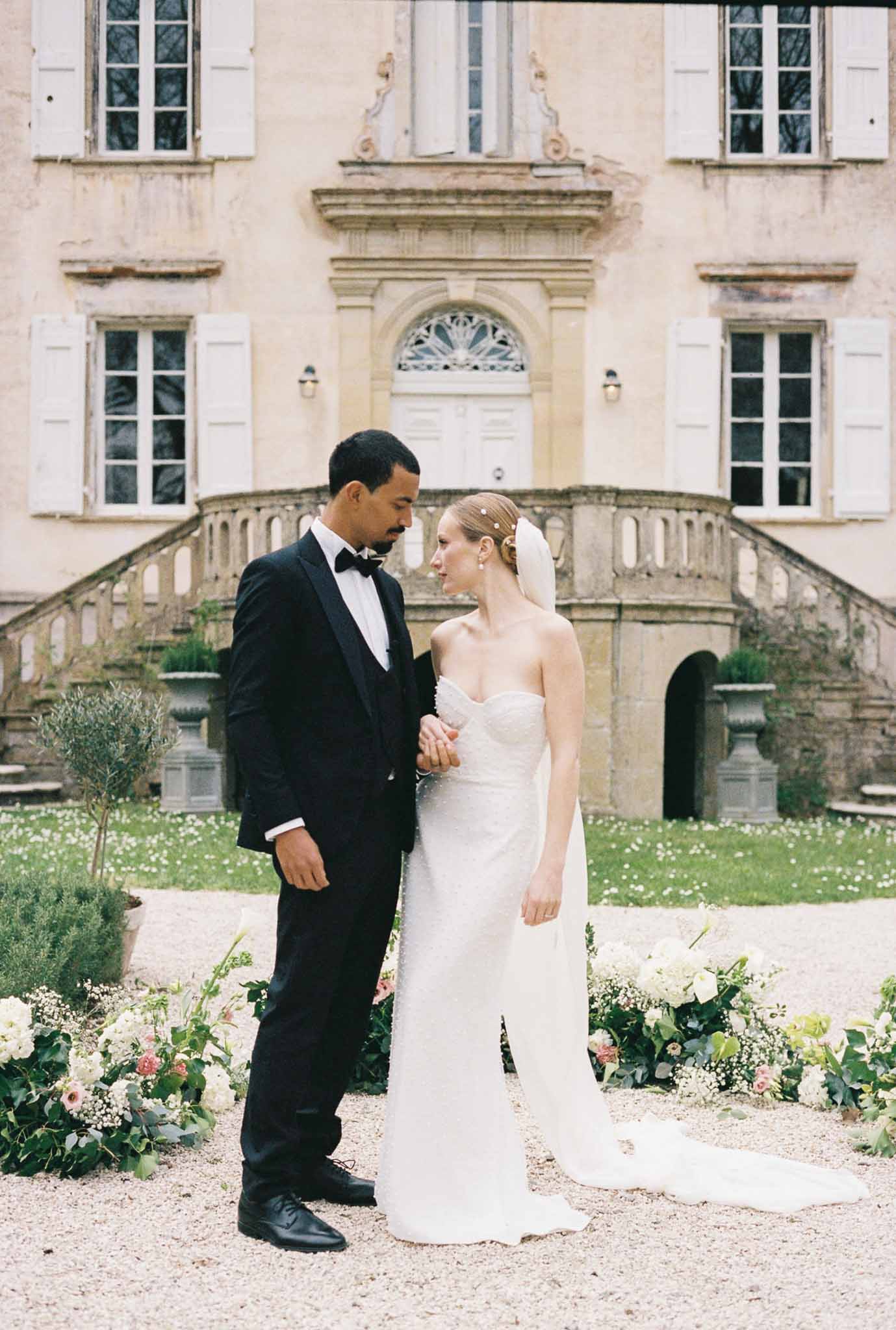 Bride and groom portrait in classical chÃƒÂ¢teau courtyard with double staircase and architectural details