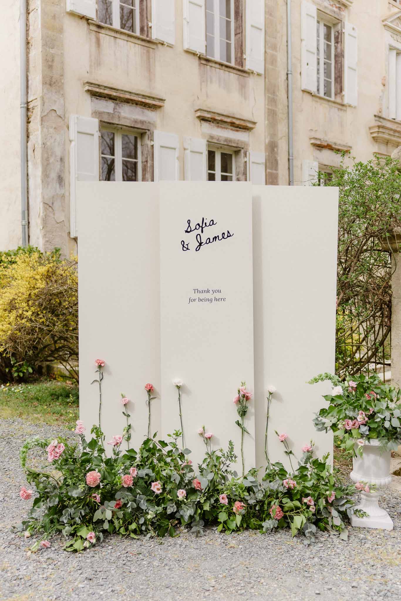 Welcome sign with pink flowers at French chÃƒÂ¢teau wedding venue