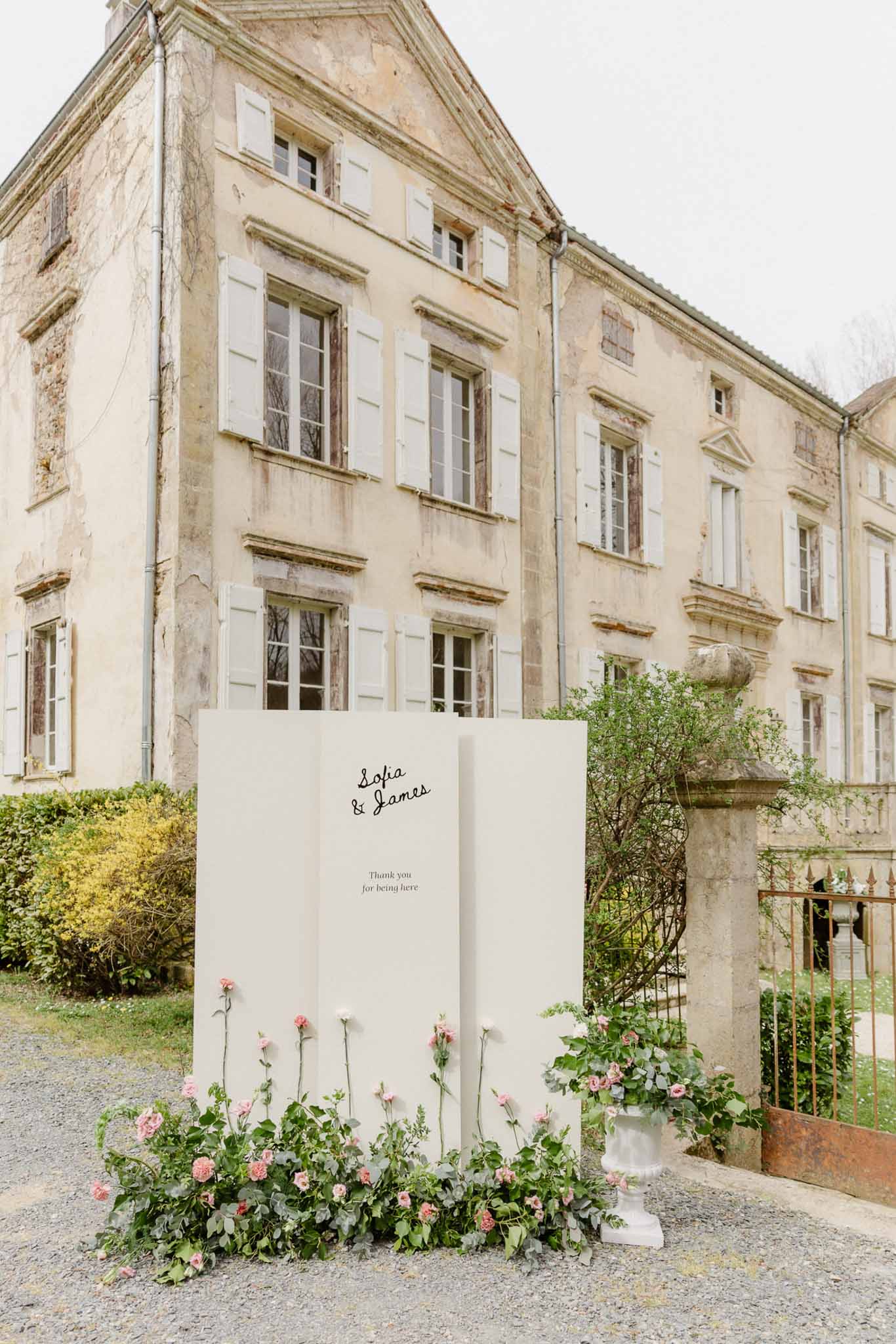 Wedding welcome sign with pink florals in historic chÃƒÂ¢teau courtyard