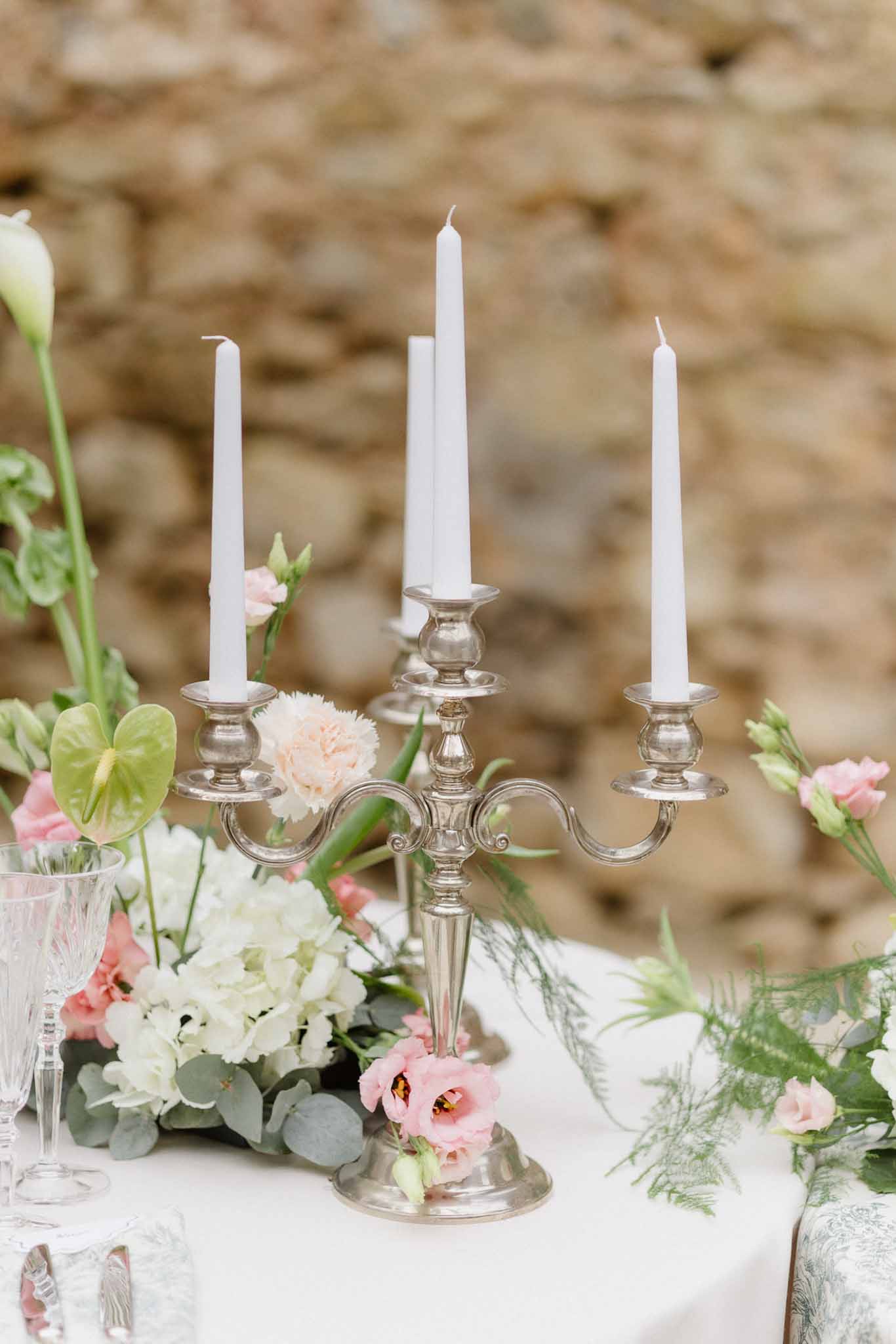 Silver candelabra centerpiece with blush and white flowers at elegant reception table