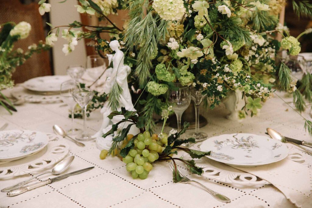 versailles detail shot reception table grapes floral centerpiece white plates napkins silverware