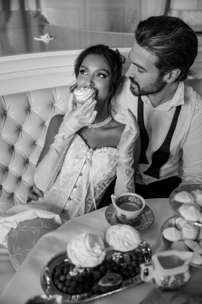 Chateau de Ferrieres Avecamour bride leaning groom chest eating cupcake black white photo