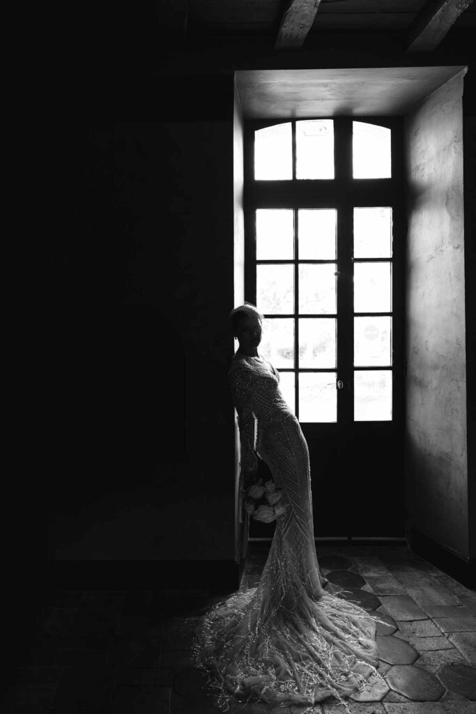Chateau de Maillac Ala Breskaya bride mermaid lace fringe sparkle longsleeves dress window black white photo