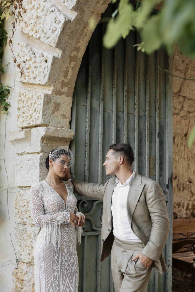 Chateau de Maillac Ala Breskaya groom hands wall looking bride leaning wall garden