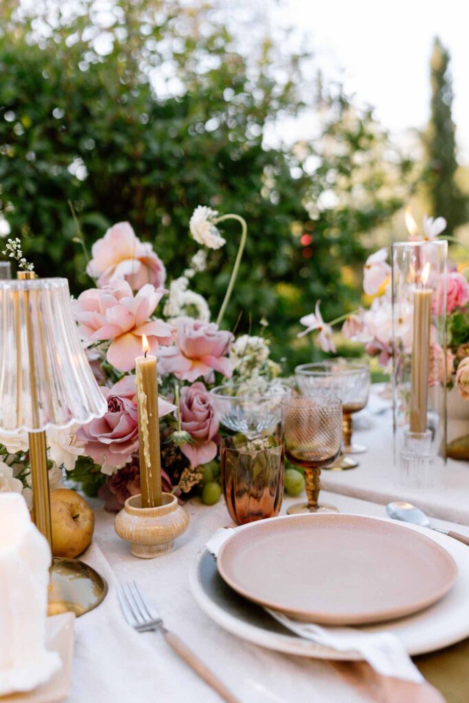 Chateau de la gruerie detail shot reception table pink plates candles lamps glasses flowers