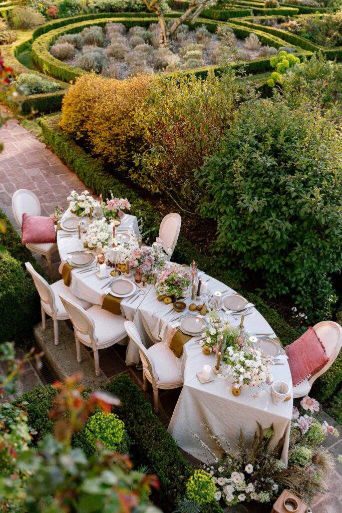 Chateau de la gruerie detail shot reception table pink theme plates candles lamps top view garden landscape
