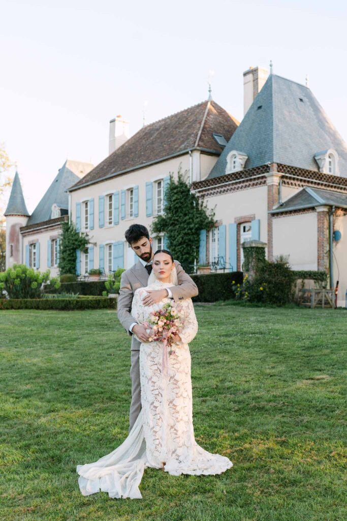 Chateau de la gruerie groom hugging bride back garden open field area