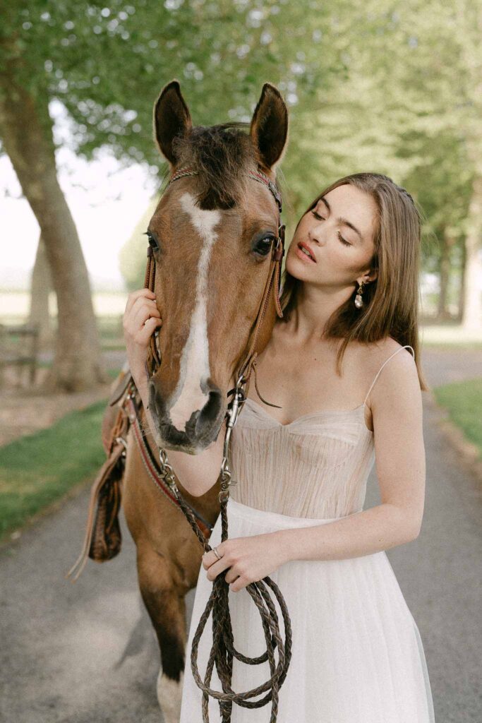 Chateau sainte claire keith flament bride holding horse face leash tulle dress