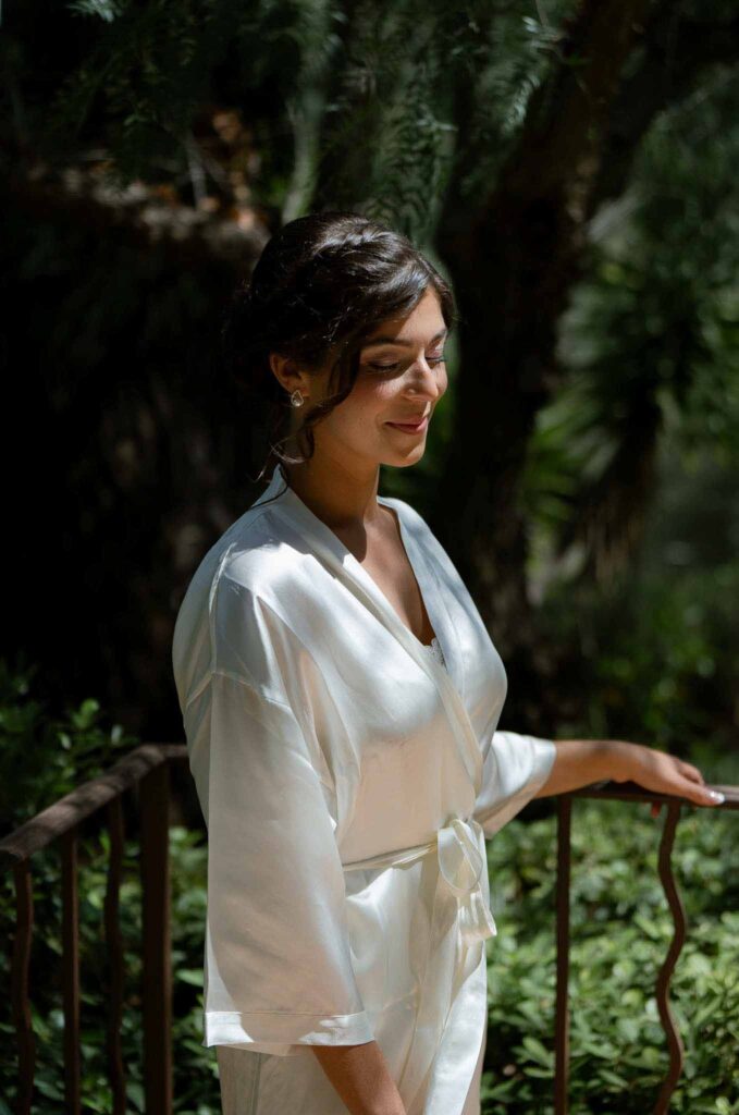 manoir de letang myrto events bride getting ready silk robe outside sunlight garden