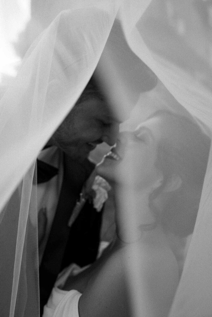 manoir de letang myrto events bride groom almost kiss inside veil black white photo