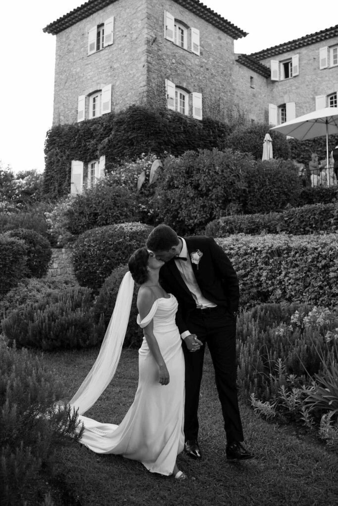 manoir de letang myrto events bride groom holding hand kissing garden black white photo