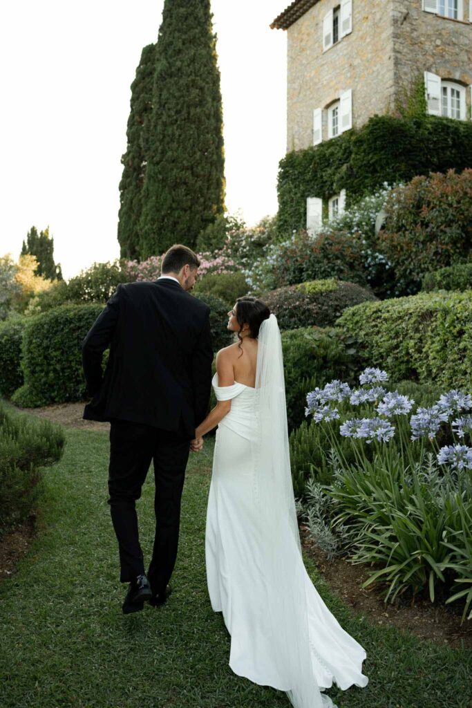 manoir de letang myrto events bride groom holding hand looking each other walking garden