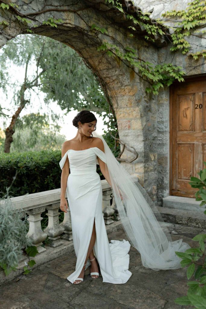 manoir de letang myrto events bride off shoulder sweet heart neckline high slit dress long veil