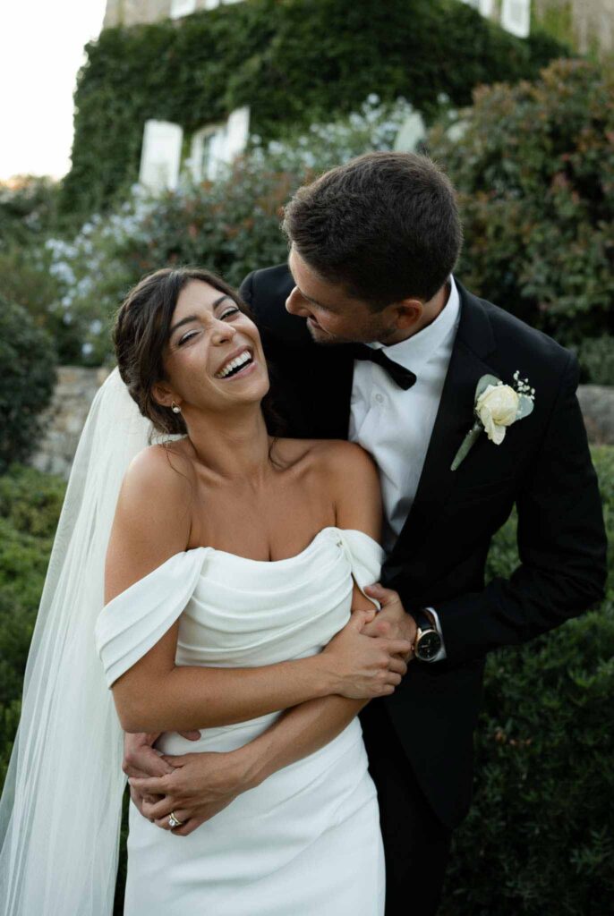 manoir de letang myrto events gromm hug back bride looking at each other garden area
