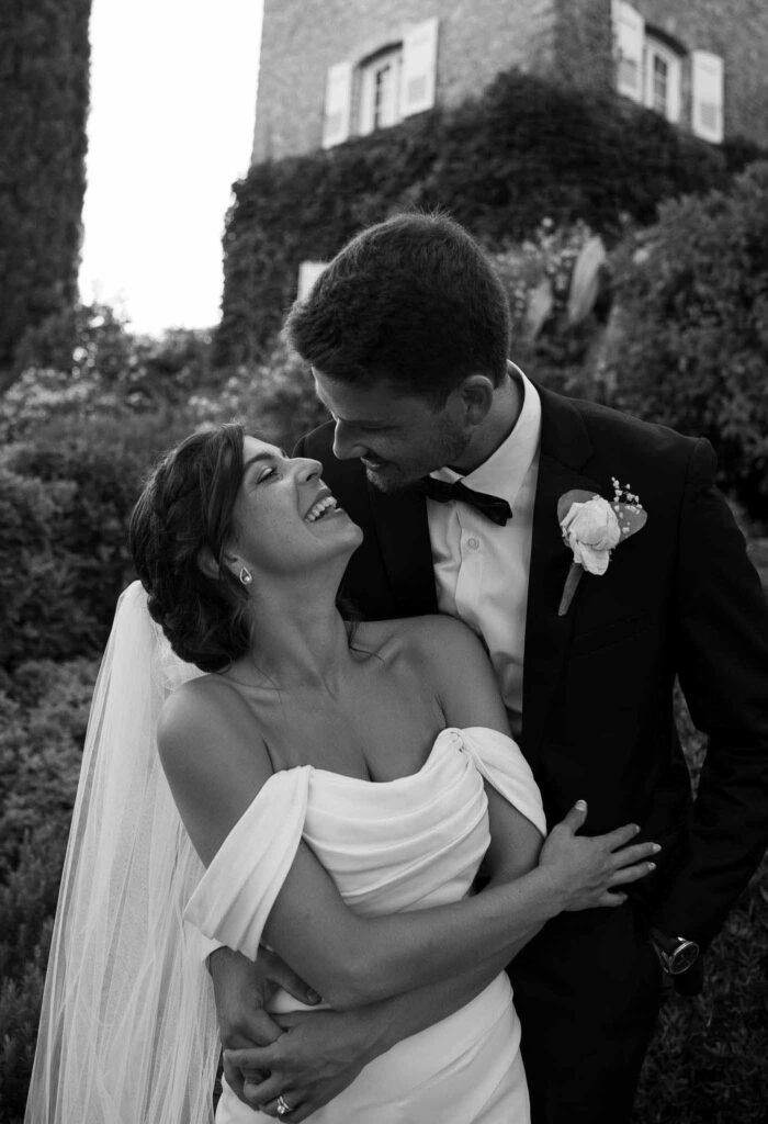 manoir de letang myrto events gromm hug back bride looking at each other kissing black white photo