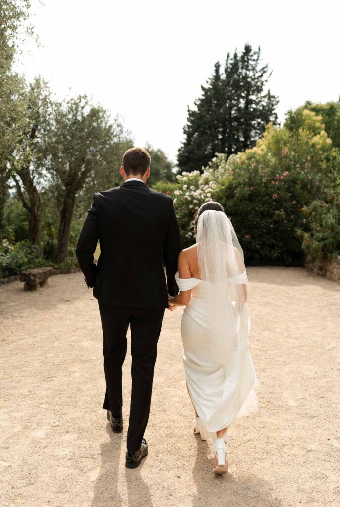 manoir de letang myrto events groom bride holding hands walking back shot
