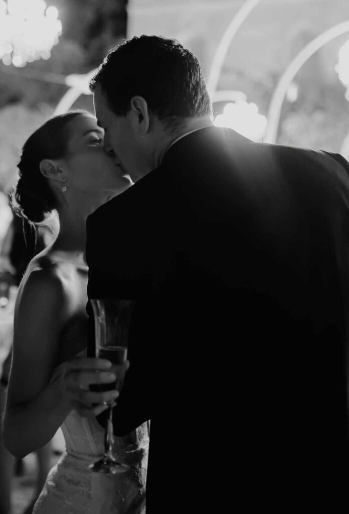 Chateau de Robernier Elise Morgan bride groom kissing holding champagne glass black white photo