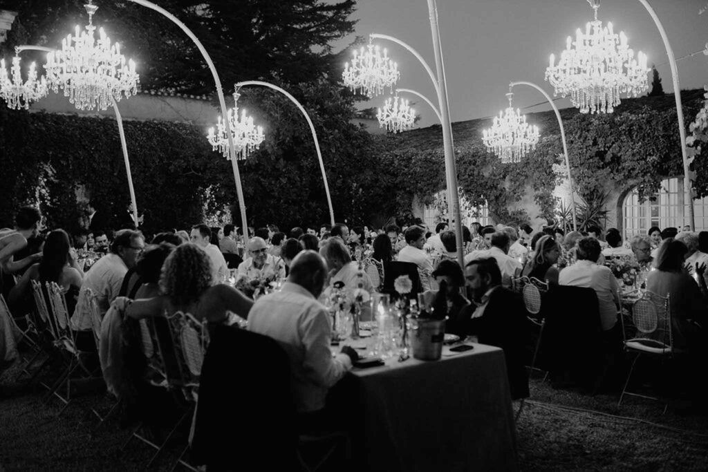 Chateau de Robernier Elise Morgan guests seated reception tables chandeliers light up black white photo