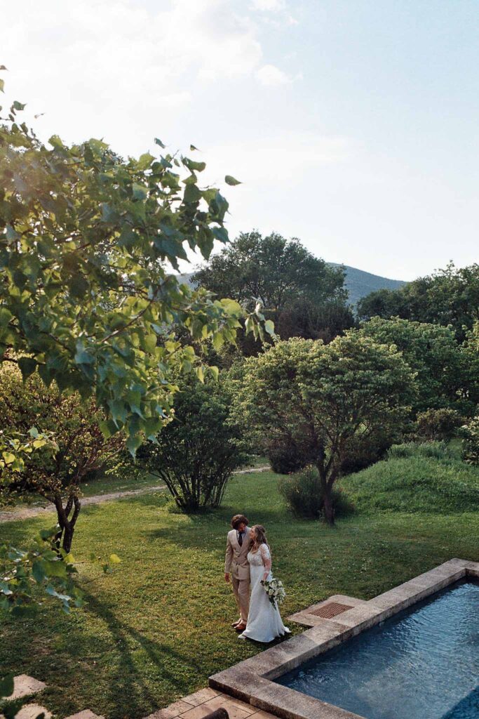 MCaelicia Galinier Lourmarin bride groom walking around pool area garden sunset