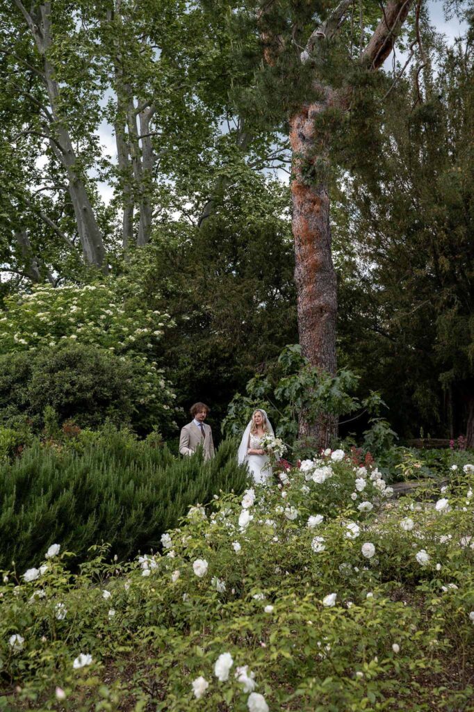 MCaelicia Galinier Lourmarin bride groom walking flower garden trees venue