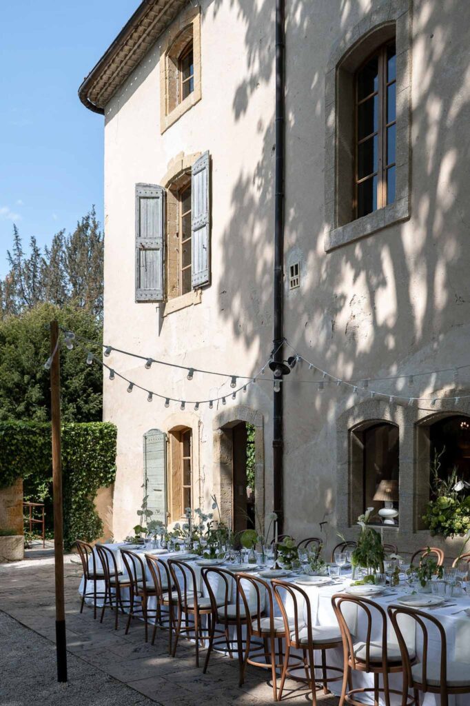 MCaelicia Galinier Lourmarin detail shot long reception table stringlights wood chairs