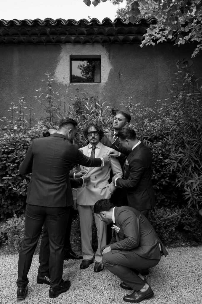 MCaelicia Galinier Lourmarin groom groomsmen get ready outside black white photo
