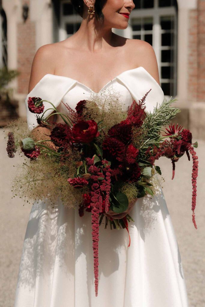 Chateau de Glairans Labricole bride holding red wild flower bouquet