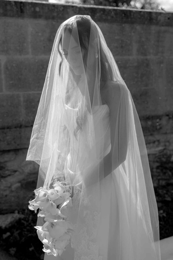 Chateau de Pondres Angie Graphy bride veil on face holding bouquet black white photo