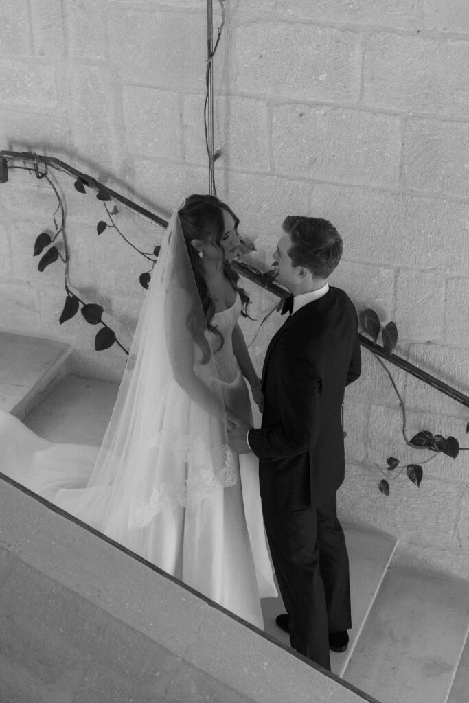 Chateau de Pondres Angie Graphy groom first look bride stairs black white photo