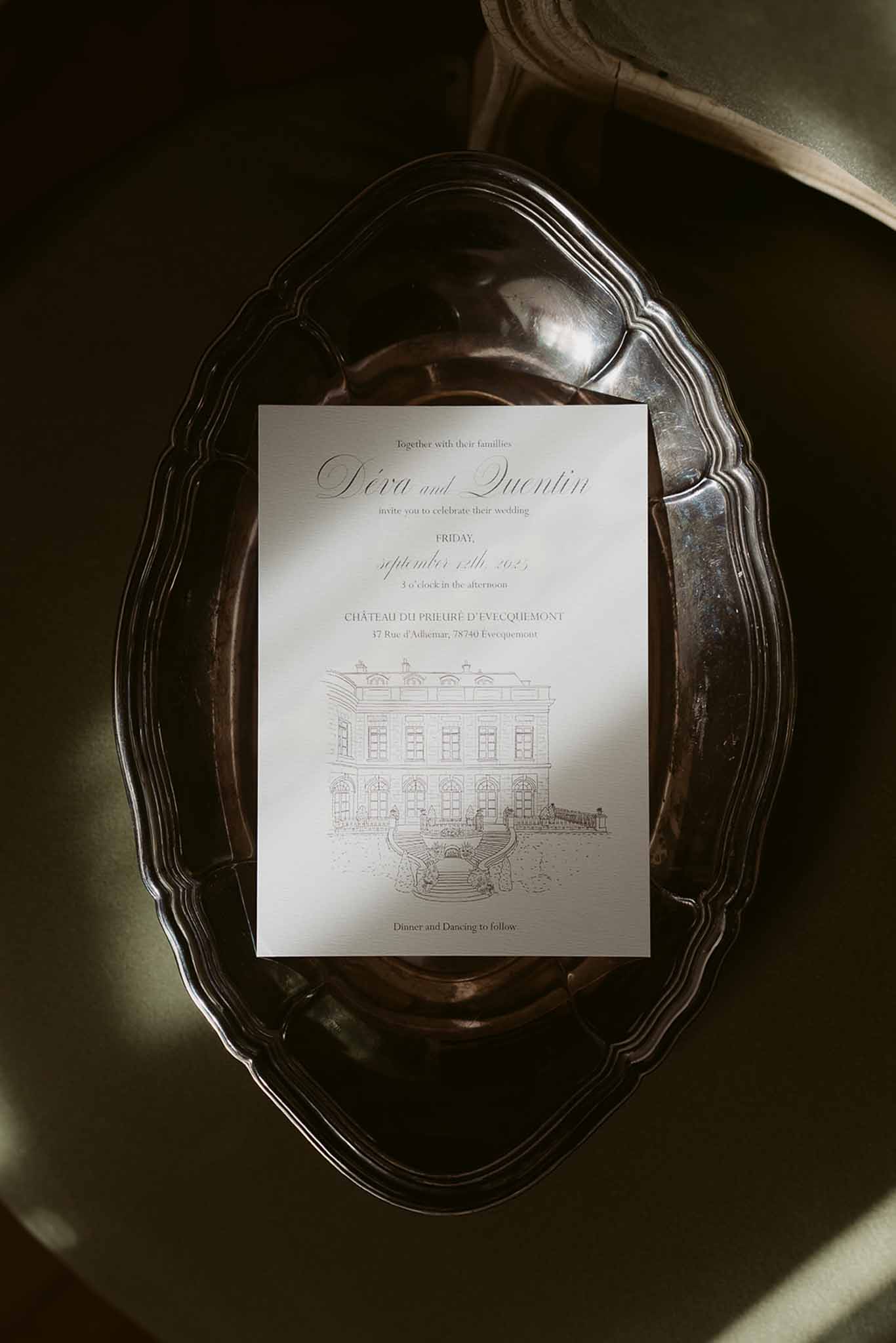 Calligraphy invitation with architectural chateau illustration on cream card stock placed on antique silver tray