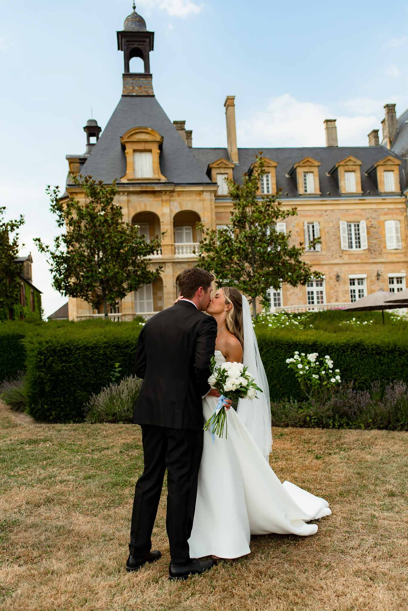 Bride and groom kissing in a garden
