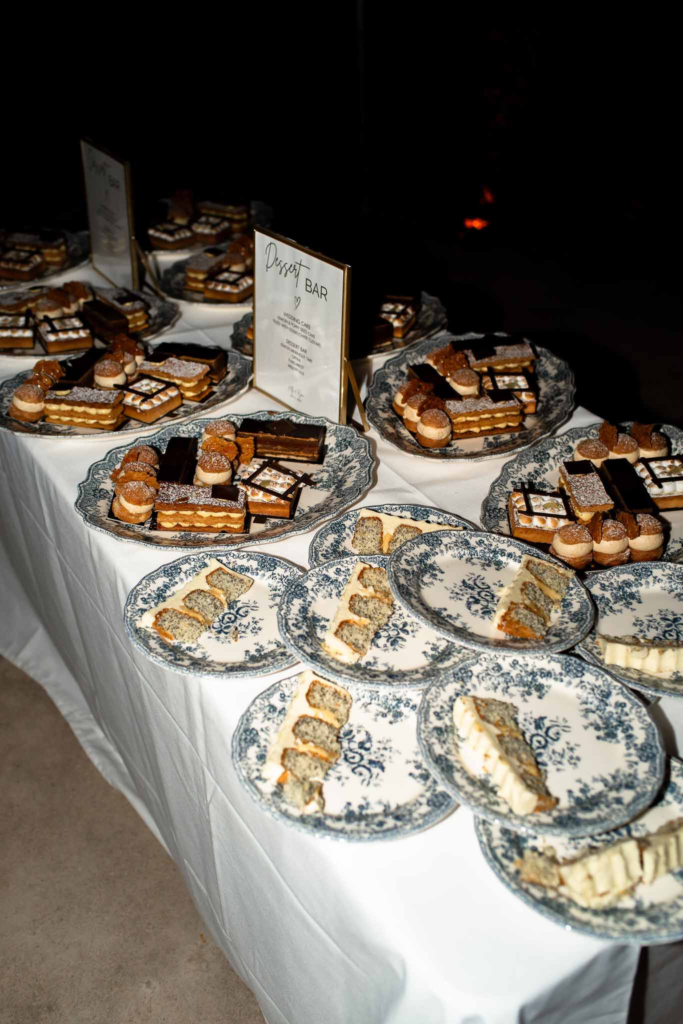 Dessert bar table with opera cake mille-feuille and choux puffs on blue transferware plates