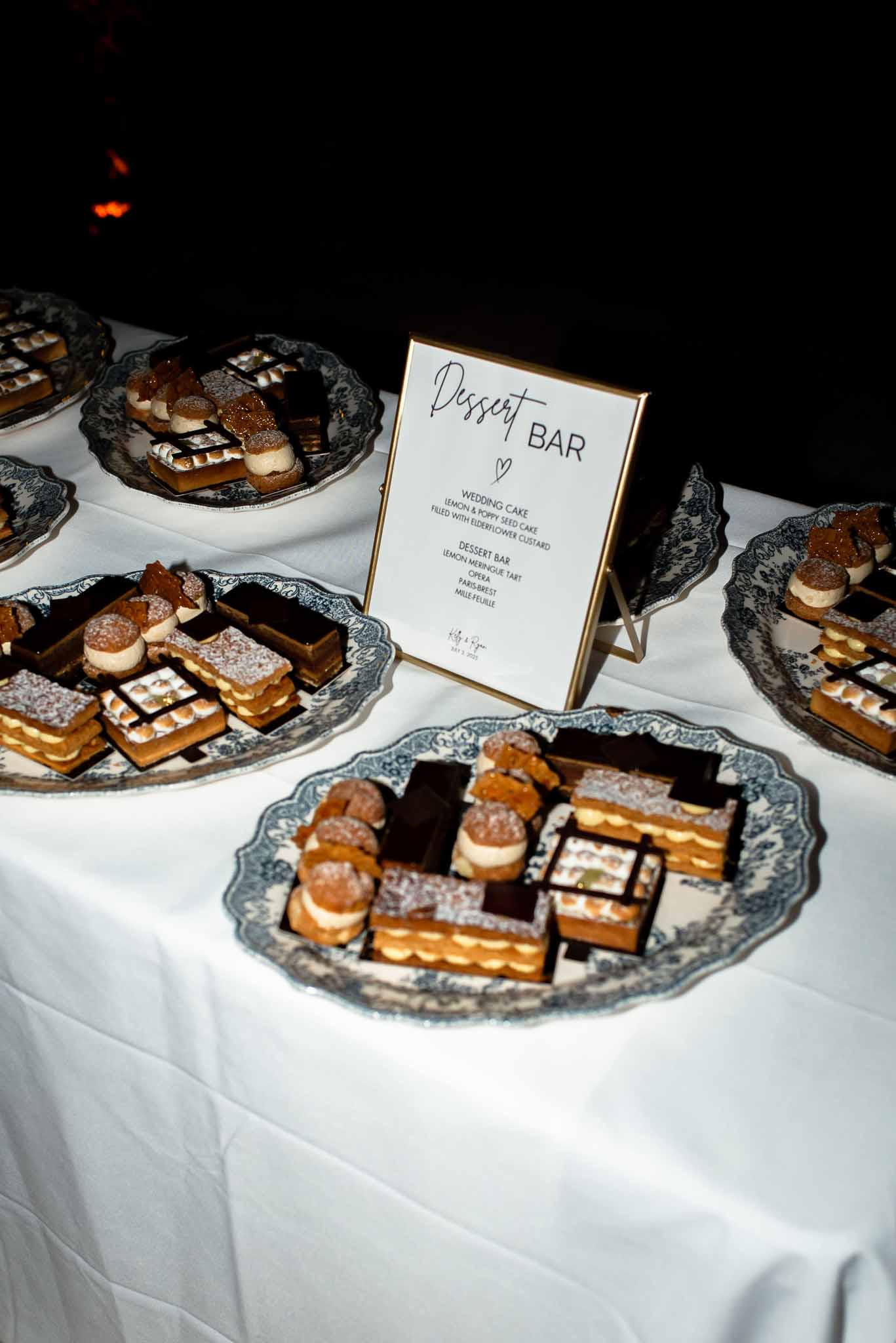 French dessert bar with mille-feuille, opera cake, Paris-Brest on blue transferware plates with gold sign